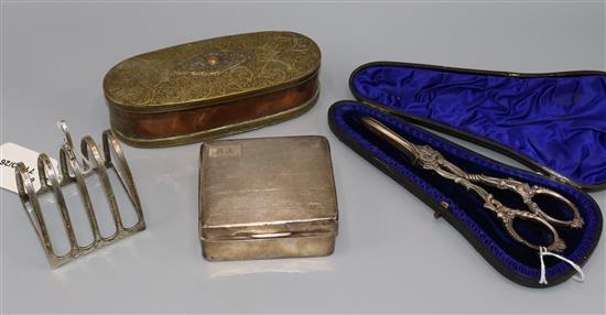 Pair of Wilkinson & Co. silver grape scissors, Sheffield 1867, three napkin rings, a toast rack and a cigarette box